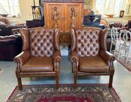 Två eleganta Chesterfield öronlappsfåtöljer