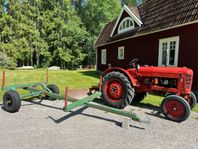 Traktor med skogsvagn och schaktblad