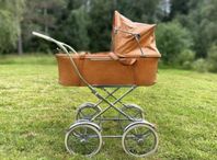 Retro barnvagn med klassiska hjul och design. 