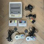 Super Nintendo med två handkontroller och två spel