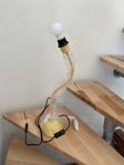 Originell bordslampa med stadig fot i gulaktig nyans