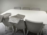 ett matbord med 6 stolar och 2 gardiner 
