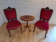 Röda sammetsstolar med tillhörande bord
