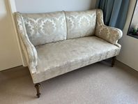 Liten tvåsitssoffa med fällbara armstöd