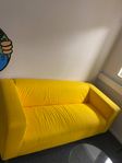 Gul soffa och ett glasbord