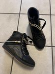 Svarta sneakers med guldkedja och nitar