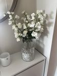 Vas med plastblommor och vita stenar