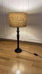 Bordslampa med svart hög fot och beige skärm