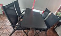 svart utomhusbord med 4 stolar