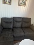 svart soffa med inbyggt benstöd 