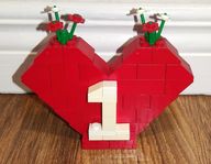 Ett dekorativt Lego hjärta med små blommor på toppen.