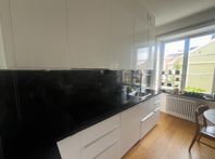 Kök IKEA med högblanka luckor och rejäl stenskiva