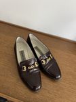Mörkbruna skinn loafers med guld detaljer