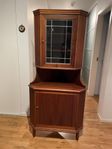 Hörnskåp i teak med blyinfattat glas i övre luckan.