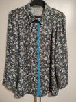 Blus med blommor och blå insatser