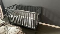 Grå spjälsäng inklusive spjälskydd från Baby Dan