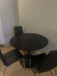 Svart bord med tre stolar 
