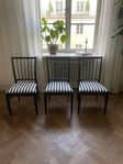 Svarta stolar i trä m. randig tygdyna 