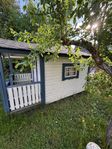 Fin och rymlig lekstuga i trä – veranda & inredd!