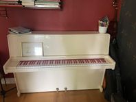 Ett superfint benvitt piano med röda tangenter.