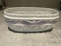 Vit oval kruka ytterfoder med lila blommor, längd 26 cm