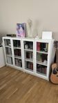 Två vita Ikea bokhyllor med glasdörrar