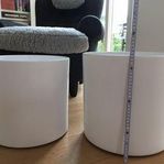 Två stora vita cylinderformade krukor
