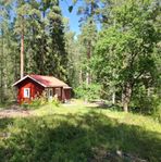 Röd liten stuga i Gäddesta småstuge-område (Karlslund)