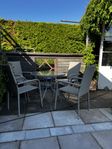 liten utemöbelgrupp i konstrotting med glasbord