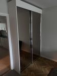 Garderob med rökfärgat spegelglas. 