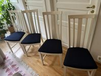 Fyra vita matrumsstolar med hög rygg och blå sits