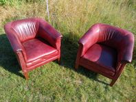 Två röda skinnfåtöljer vintage-stil