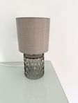 Liten grå lampa med glasfot
