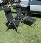 2 svarta campingstolar i mesh med nackkuddar och 1 fotpall