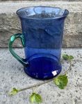 Glaskanna-blå med grönt handtag. Småländskt glasbruk.