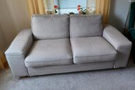 Tvåsitsig soffa i ljusa färger.