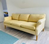 Soffa i gult tyg och ben i bok säljes 
