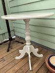 Vitmålat pelarbord. Diameter 59 cm. Höjd 69 cm.
