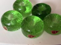 fem gröna ljusstakar i glas.